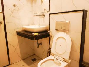 Hotel Tark Plaza Near IGI Airport Delhi في نيودلهي: حمام به مرحاض أبيض ومغسلة