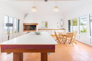 a white kitchen with a table and chairs in it at Casa Pereira – Snooker, Wi-Fi, Bbq, Pool in Relógio do Poiso