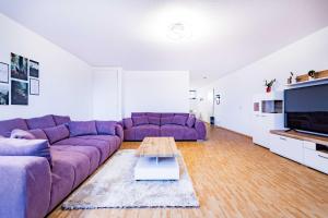 een woonkamer met een paarse bank en een tafel bij Kim Fewo 2 in Emmendingen