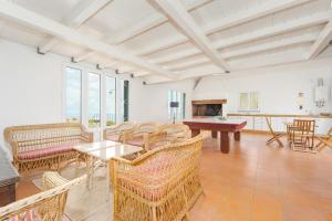 a living room with chairs and a table and a fireplace at Casa Pereira – Snooker, Wi-Fi, Bbq, Pool in Relógio do Poiso