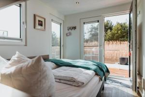 - une chambre avec un lit et une porte coulissante en verre dans l'établissement Hausboot Cosy Home - LP16, à Laasow