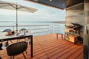 a balcony with a table and chairs on a boat at Hausboot Cosy Home - LP16 in Laasow