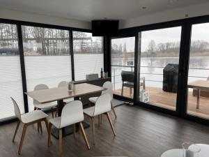 a dining room with a table and chairs and a large window at Hausboot Bakerman in Zehdenick