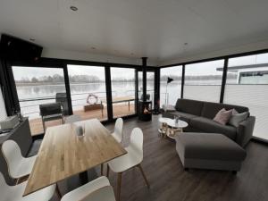 a living room with a couch and a table and chairs at Hausboot Bakerman in Zehdenick