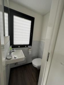 a bathroom with a sink and a toilet and a window at Hausboot Bakerman in Zehdenick