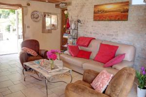 uma sala de estar com um sofá, cadeiras e uma mesa em Le Petit Paradis em Saint-Pompain