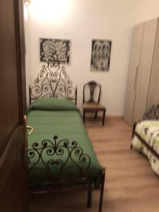 Un dormitorio con una cama verde y una silla en Il Sogno, en Acquapendente