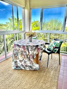 a table and chairs in a room with windows at Elysian Retreat in Ballito