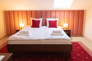 sypialnia z dużym łóżkiem z czerwonymi ścianami w obiekcie Hotel Hetman w mieście Kroczyce