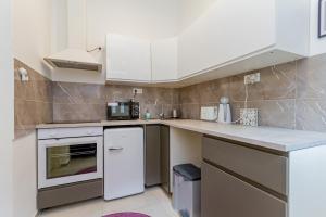 een keuken met witte kasten en een aanrecht bij I.K.Apartments in Boedapest
