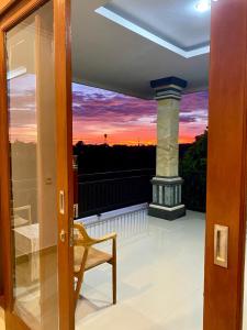 a view from the door of a balcony with a sunset at Tirta Kemala House in Ubud