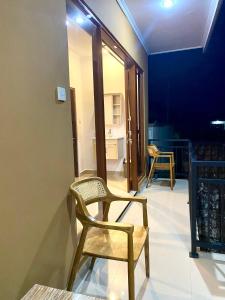 a room with two chairs and a room with a kitchen at Tirta Kemala House in Ubud