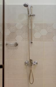 een douche met een douchekop in de badkamer bij I.K.Apartments in Boedapest