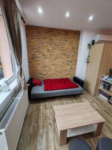 a room with a bed with a brick wall at Apartmán u Kulíška in Prievidza