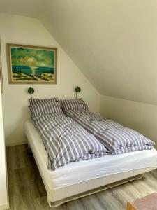 a bed with striped sheets in a room at Grethelund - 50m2 in Silkeborg