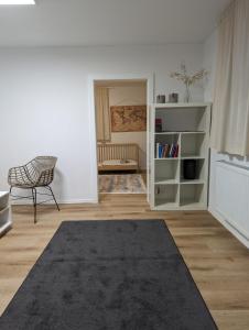 - un salon avec une chaise et une étagère dans l'établissement Ferienwohnung nahe Europa Park, à Lahr/Schwarzwald