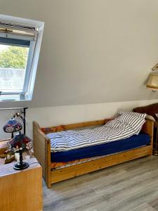 a bedroom with a wooden bed with a window at Grethelund - 50m2 in Silkeborg