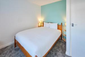 een slaapkamer met een groot wit bed en een kast bij Host & Stay - St Mark's Close in Marske-by-the-Sea