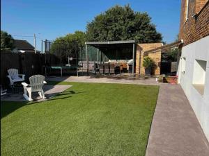 a backyard with a lawn with a table and chairs at Apartamento Mejorada del campo in Mejorada del Campo