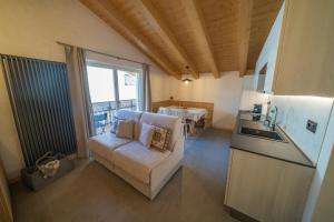 een woonkamer met een bank en een keuken met een tafel bij Appartamenti da Costantino in Padola