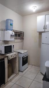 a kitchen with a stove and a microwave at Ótima casa em Unamar in Cabo Frio