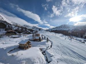 una pista cubierta de nieve con un lodge de esquí en una montaña en Le plus grand appartement, 150 M2, et la plus belle vue d'Isola 2000 Front de Neige en Isola 2000