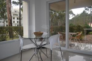 プンタ・デル・エステにあるGreen Park - Lloret de Mar Punta del Esteの窓付きの客室で、ガラスのテーブルと椅子が備わります。