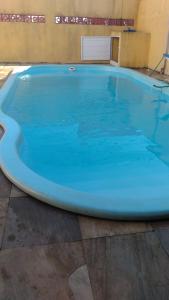 a large blue swimming pool in a building at Ótima casa em Unamar in Cabo Frio +13 photos
