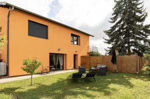 een huis met een tuin met stoelen en een patio bij La casa Irignoise in Irigny