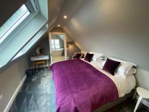 a bedroom with a large bed with a purple blanket at The Lodge at Muir Estate in Thornhill