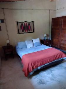 Un dormitorio con una cama grande con una manta roja. en La Escondida, en Tilcara 18 fotos más