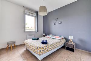 Schlafzimmer mit einem Bett mit blauen Wänden und einem Fenster in der Unterkunft L'écrin Jardin des Remparts - Parking Privé - Terrasse in Carcassonne