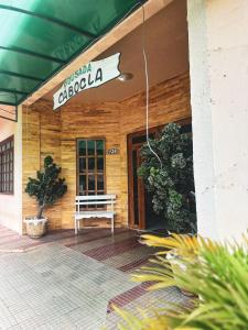 a sign on the front of a building with a bench at Pousada Cabocla in Alter do Chao