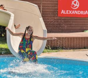 a woman riding a water slide in a pool at Rena Hotel - All Inclusive in Sunny Beach
