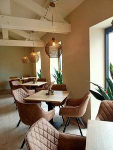 un restaurante con mesas, sillas y luces colgantes en EuroParcs Poort van Maastricht en Berg en Terblijt