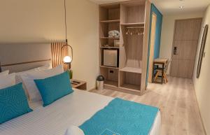 um quarto com uma cama grande e almofadas azuis em Hotel Fontana Bogotá em Bogotá