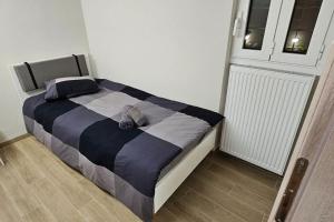 uma cama com um edredão preto e branco num quarto em All seasons house em Atenas