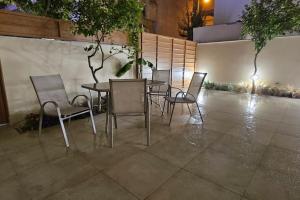 einen Tisch und Stühle in einem Innenhof mit einem Tisch und einem Stuhl in der Unterkunft All seasons house in Athen