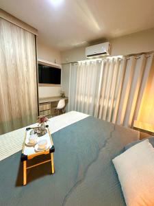ein Schlafzimmer mit einem großen Bett und einem Tablett darauf in der Unterkunft Apartamento completo e encantador in Ribeirão Preto