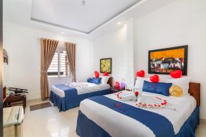 um quarto com 2 camas com decorações vermelhas em Amona Hotel em Hue