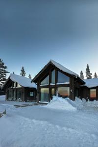 una casa con nieve en el suelo delante de ella en Luxurious Mountain Lodge, en Ljørdal