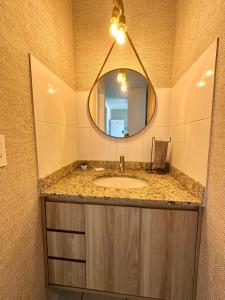 Apartamento completo e encantador في ريبيراو بريتو: حمام مع حوض ومرآة