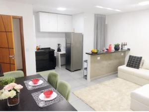 a kitchen and a living room with a dining room table and a kitchen at Flat Aeroporto Internacional de GRU 6 in Guarulhos