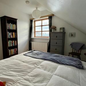 1 dormitorio con cama blanca y ventana en Guesthouse at Dynjandi Falls, en Bíldudalur