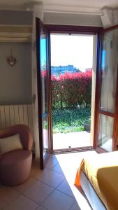 um quarto com uma grande porta de vidro deslizante com uma cadeira em Giardino del sole, con Wi-Fi, smart TV, aria condizionata em Borgo a Buggiano