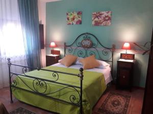 Schlafzimmer mit einem Bett mit grüner Tagesdecke in der Unterkunft I Casali in Calatabiano