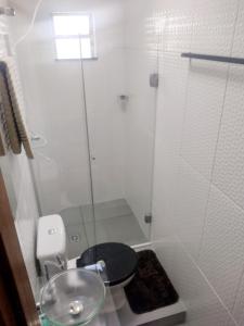 a bathroom with a toilet and a glass shower at Flat Aeroporto Internacional de GRU 4 in Guarulhos