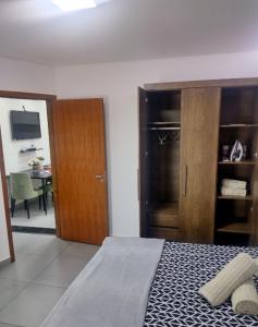 a bedroom with a bed and a wooden closet at Flat Aeroporto Internacional de GRU 4 in Guarulhos