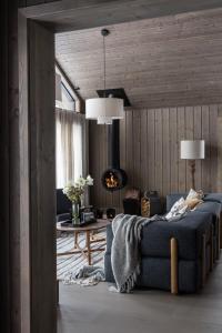 sala de estar con sofá y chimenea en Luxurious Mountain Lodge en Ljørdal