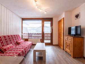 a living room with a couch and a tv at Les Sitelles - 12 - Appt vue montagne - 6 pers in Morillon
